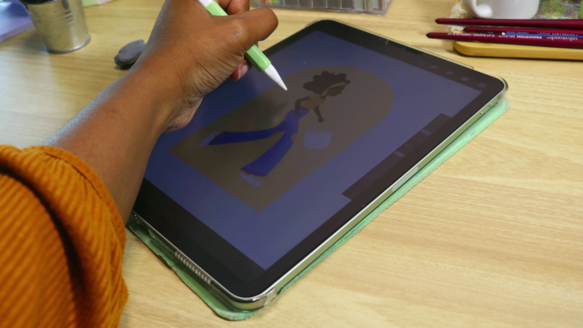 A hand holding an apple pencil hovers over a digital drawing on an ipad