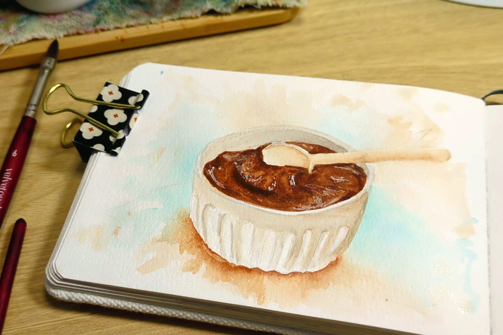 a watercolor painting of a bowl of chocolate frosting
